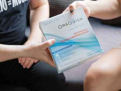 An HIV counselor hands a test to a client