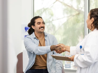 Young Latino man shakes hands with his new HIV care specialist