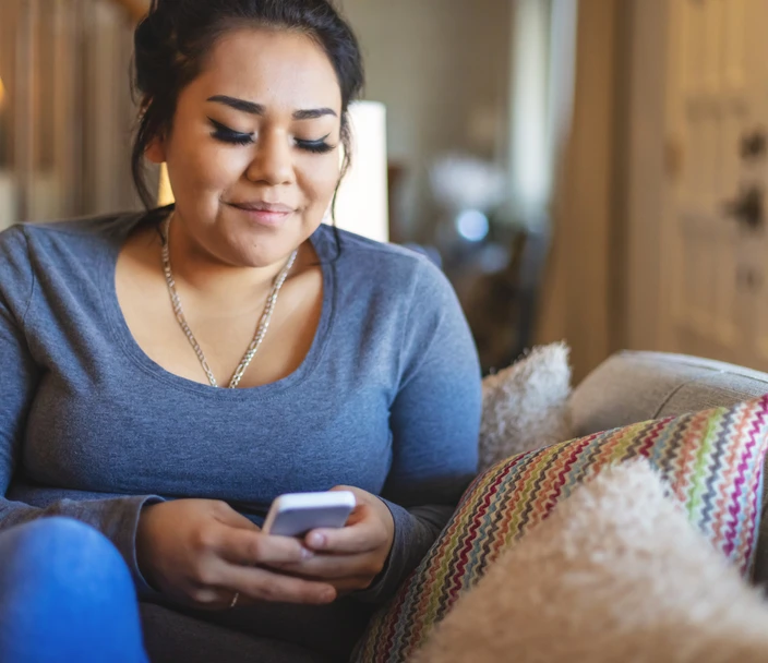 Young American Indian woman uses her phone to locate free HIV testing services