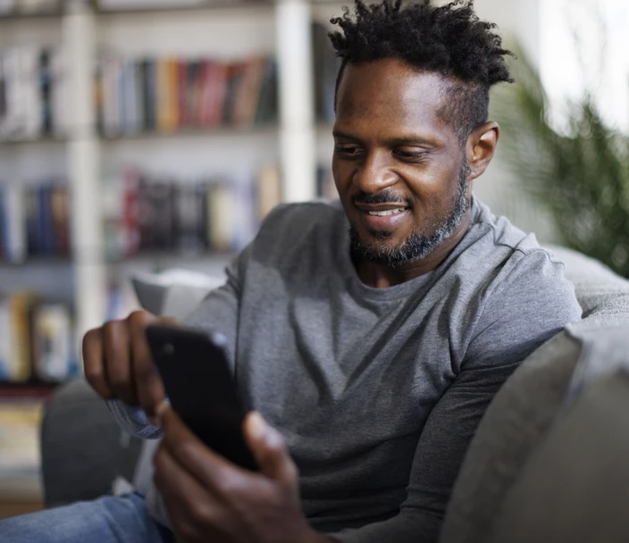 A Black man browses HIV testing locations on his smart phone