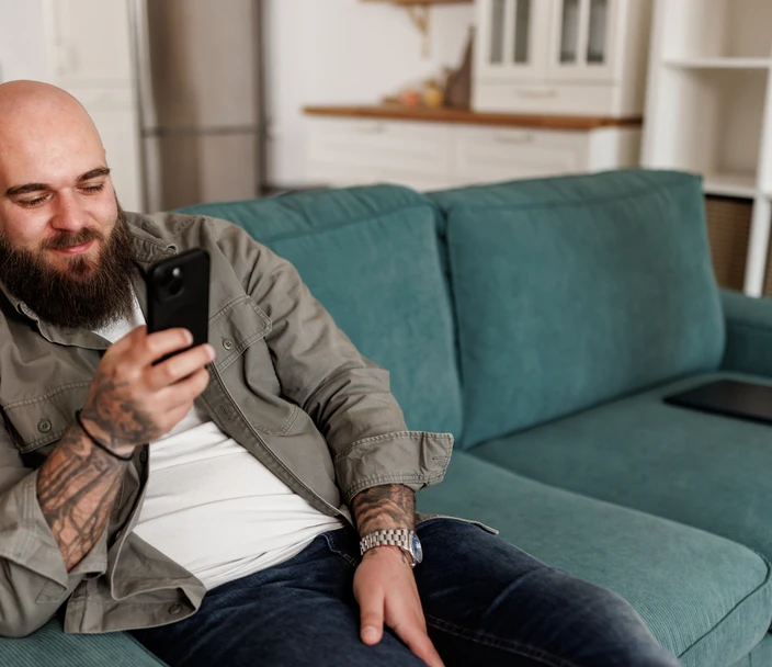 Relaxed young man uses his phone to look up an HIV clinical care provider