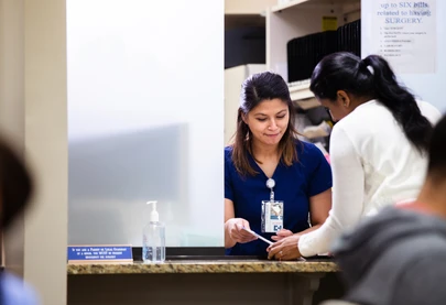 A woman checks in for an appointment at her local health clinic