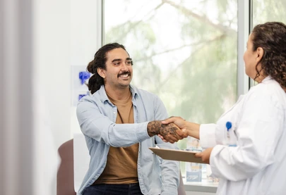 Young Latino man shakes hands with his new HIV care specialist