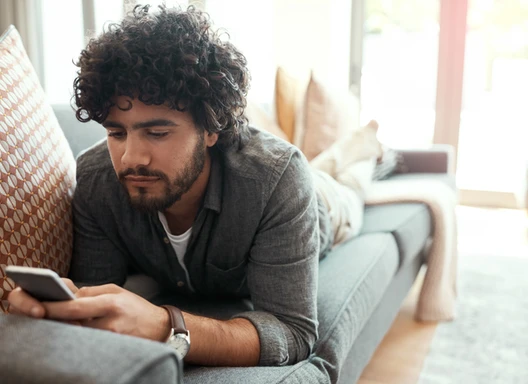 A young man accesses web resources on his smart phone