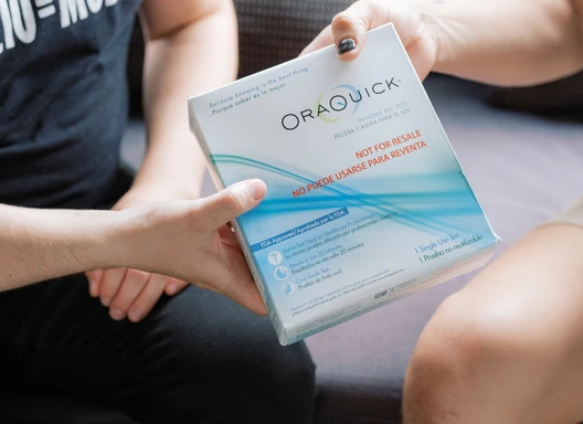 An HIV counselor hands a test to a client