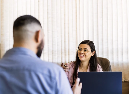 A man speaks with a Latina case manager about available services