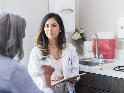 A woman clinician listens carefully to a new patient living with HIV