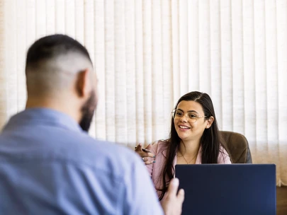 A man speaks with a Latina case manager about available services