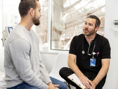 Young man speaks to a male nurse at a clinic about HIV prevention options