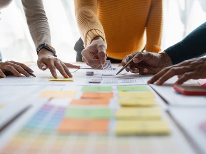 Close-up of people's hands working at a table to create a strategic plan